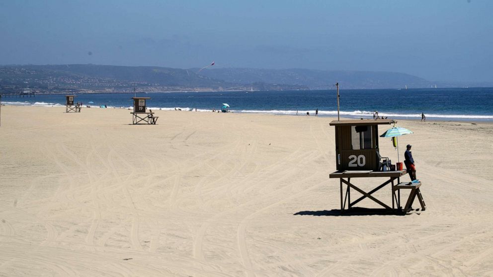 PHOTO: Lifeguards keep a lookout on a mostly empty beach, May 3, 2020, in Newport Beach, Calif. 