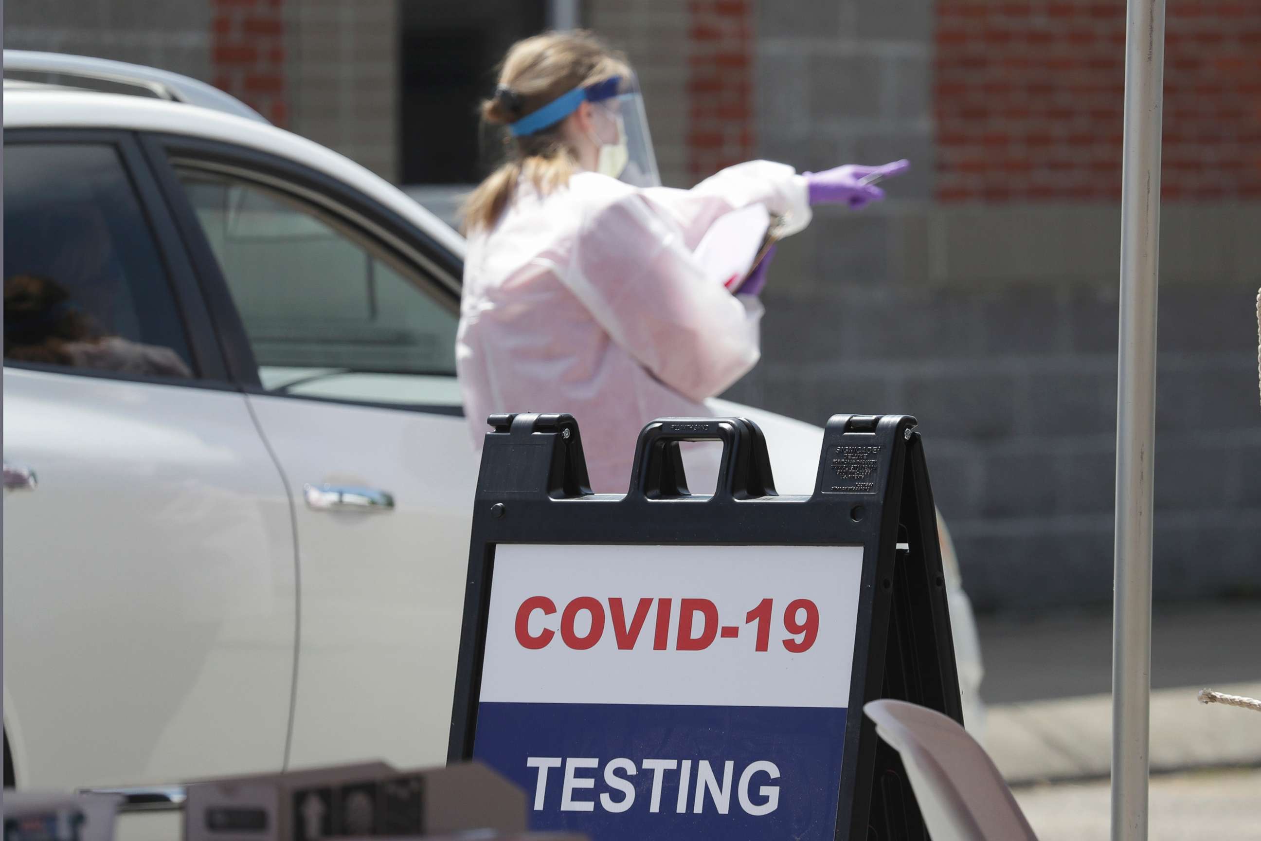 PHOTO: A worker directs a driver through a drive-through COVID-19 testing location, April 18, 2020, in Franklin, Tenn. 