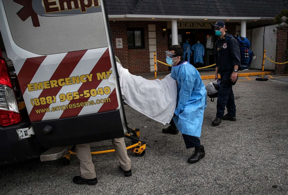 PHOTO: A medic from Empress EMS loads a suspected COVID-19 patient from the Regency Extended Care Center into an ambulance, April 7, 2020, in Yonkers, N.Y.