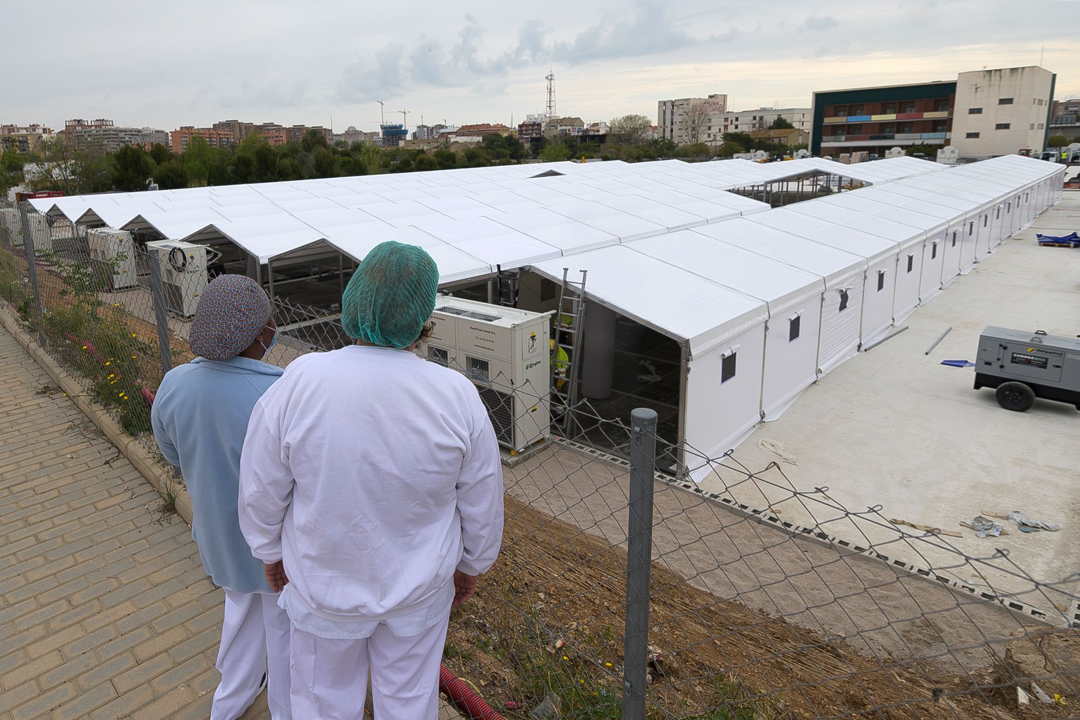 PHOTO: Nurses look at the construction site of a field hospital outside the La Fe Hospital to admit patients suffering from the COVID-19 coronavirus in Valencia, Spain, April 5, 2020.