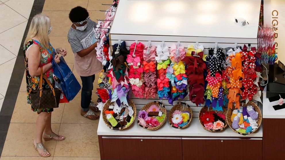 PHOTO: People shop at a kiosk at Penn Square Mall as the mall reopens, May 1, 2020, in Oklahoma City. 