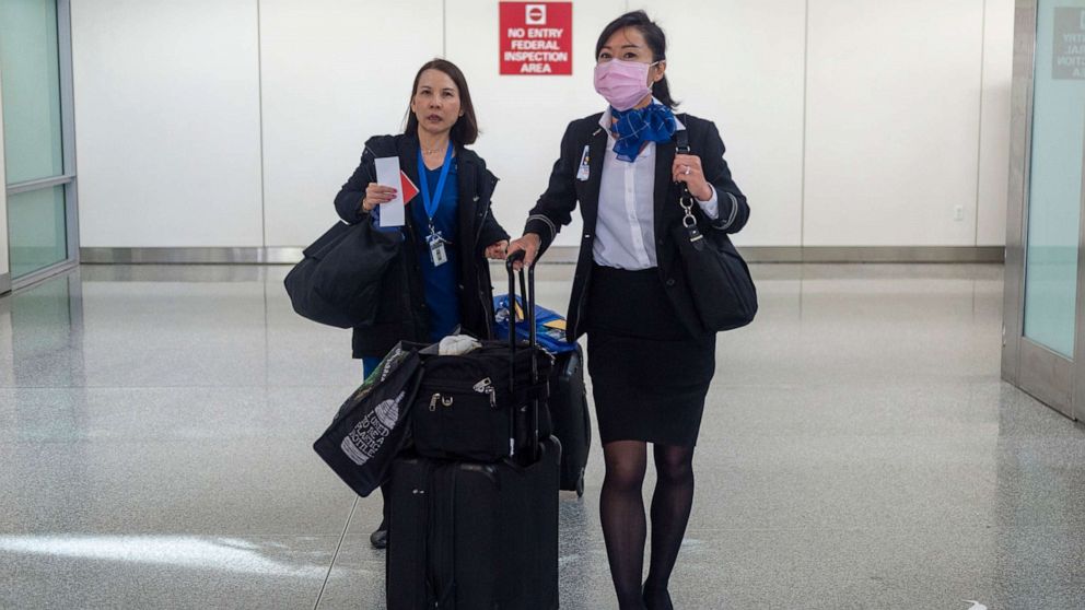 PHOTO: A United Airlines flight attendant wearing face masks walks out of the international terminal at the San Francisco International Airport in Millbrae, Calif., Jan. 31, 2020. 