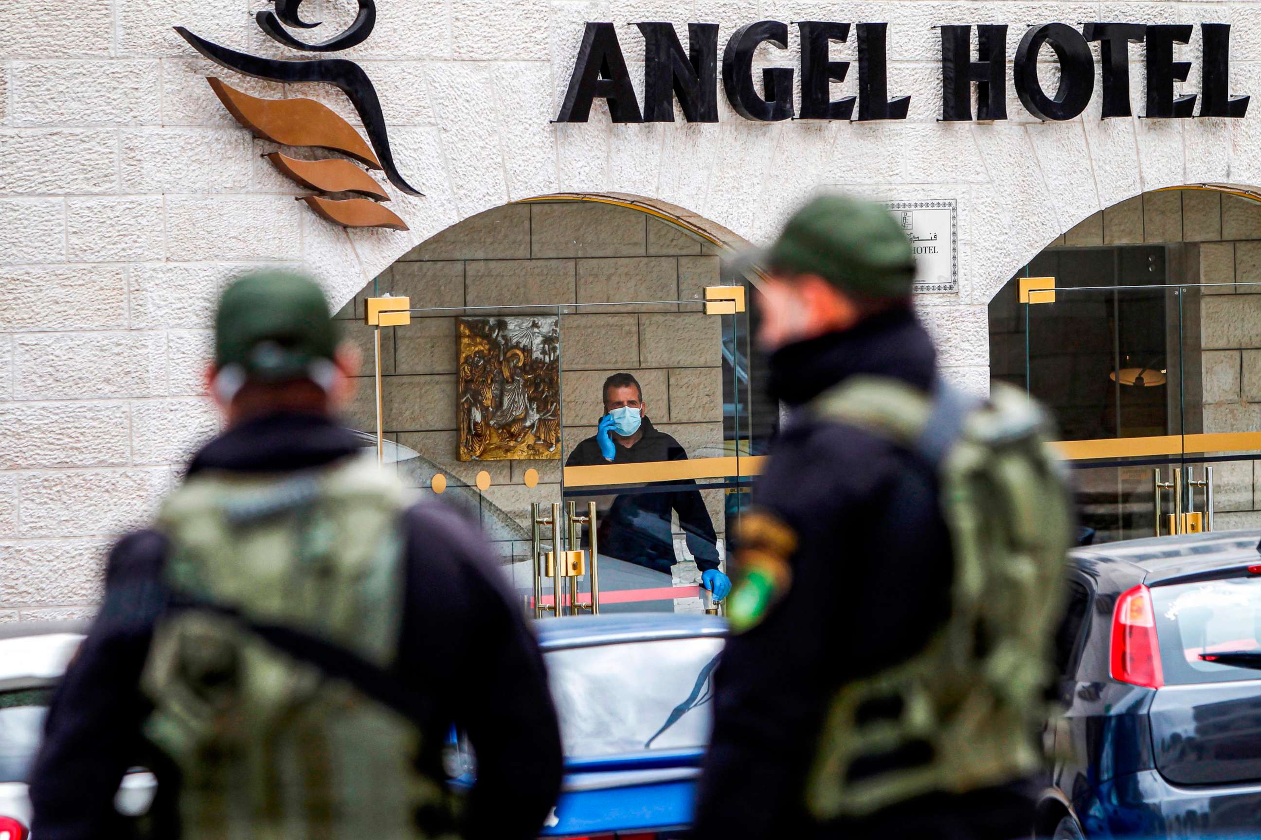 PHOTO: Palestinian security forces stand across a street from a hotel under quarantine due to the new coronavirus in the biblical city of Bethlehem in the occupied West Bank on March 7, 2020.