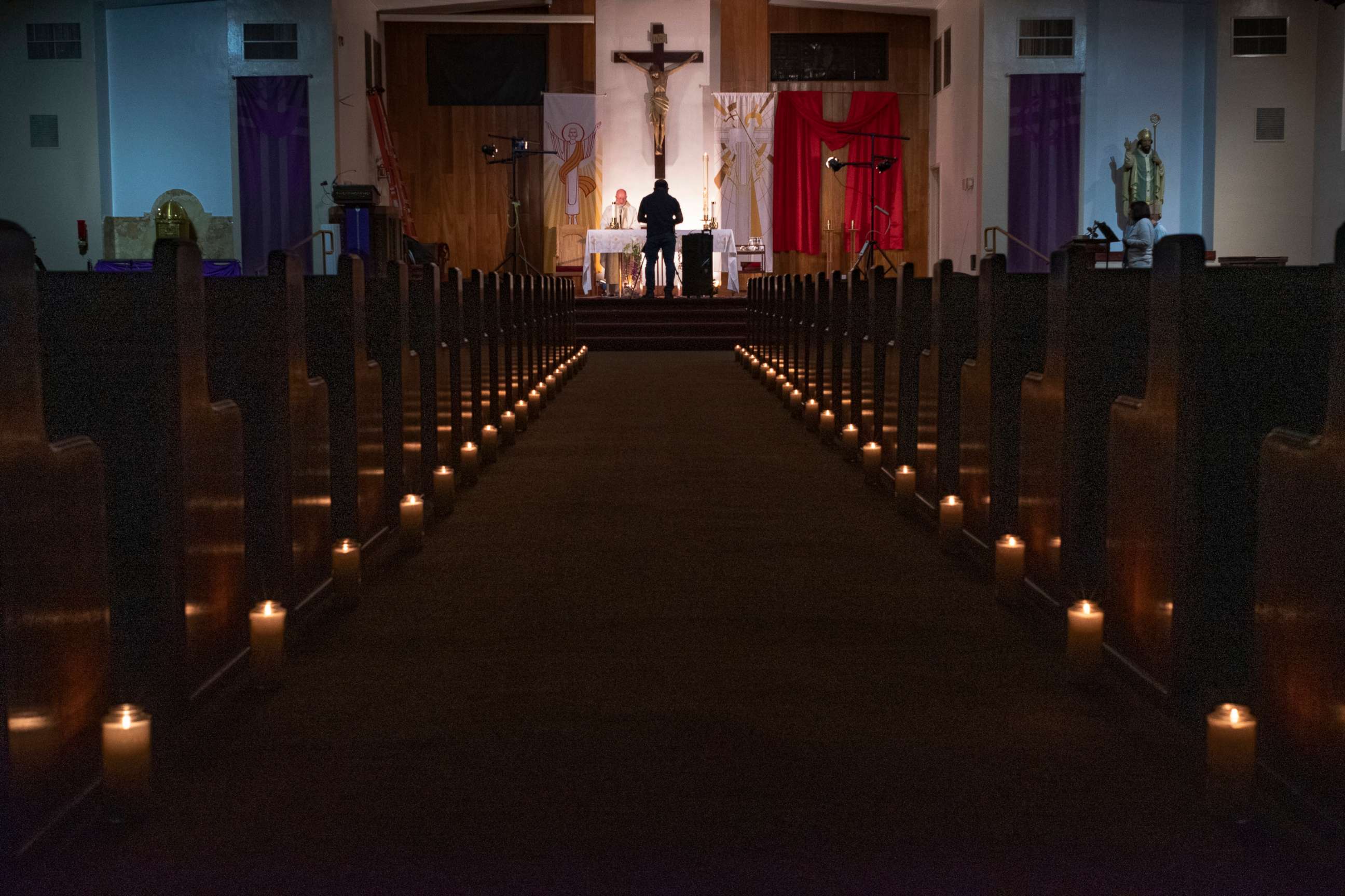 PHOTO: Pastor Nicolas Sanchez celebrates Easter Vigil Mass at his church decorated with candles and pictures sent by his parishioners attached to their pews at St. Patrick Church in North Hollywood, Calif., April 11, 2020.
