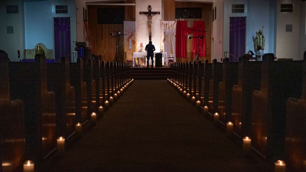 PHOTO: Pastor Nicolas Sanchez celebrates Easter Vigil Mass at his church decorated with candles and pictures sent by his parishioners attached to their pews at St. Patrick Church in North Hollywood, Calif., April 11, 2020.