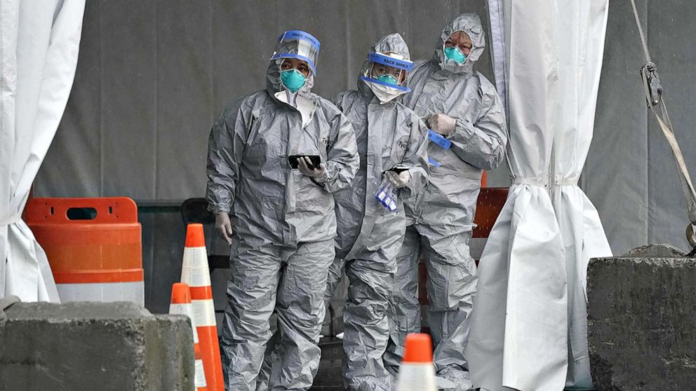 PHOTO: Workers in protective suits wait for people to arrive by car as Governor Andrew Cuomo opens the State's First Drive Through COVID-19 Mobile Testing Center at Glen Island Park, in New Rochelle, New York on March 13, 2020. 