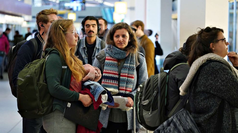 PHOTO: Passengers, including Aleksandra, left, from Poland and Sophia, center, from Germany wait to board the last direct United Airlines flight from Berlin to New York at Tegel Airport, in Berlin, March 13, 2020.
