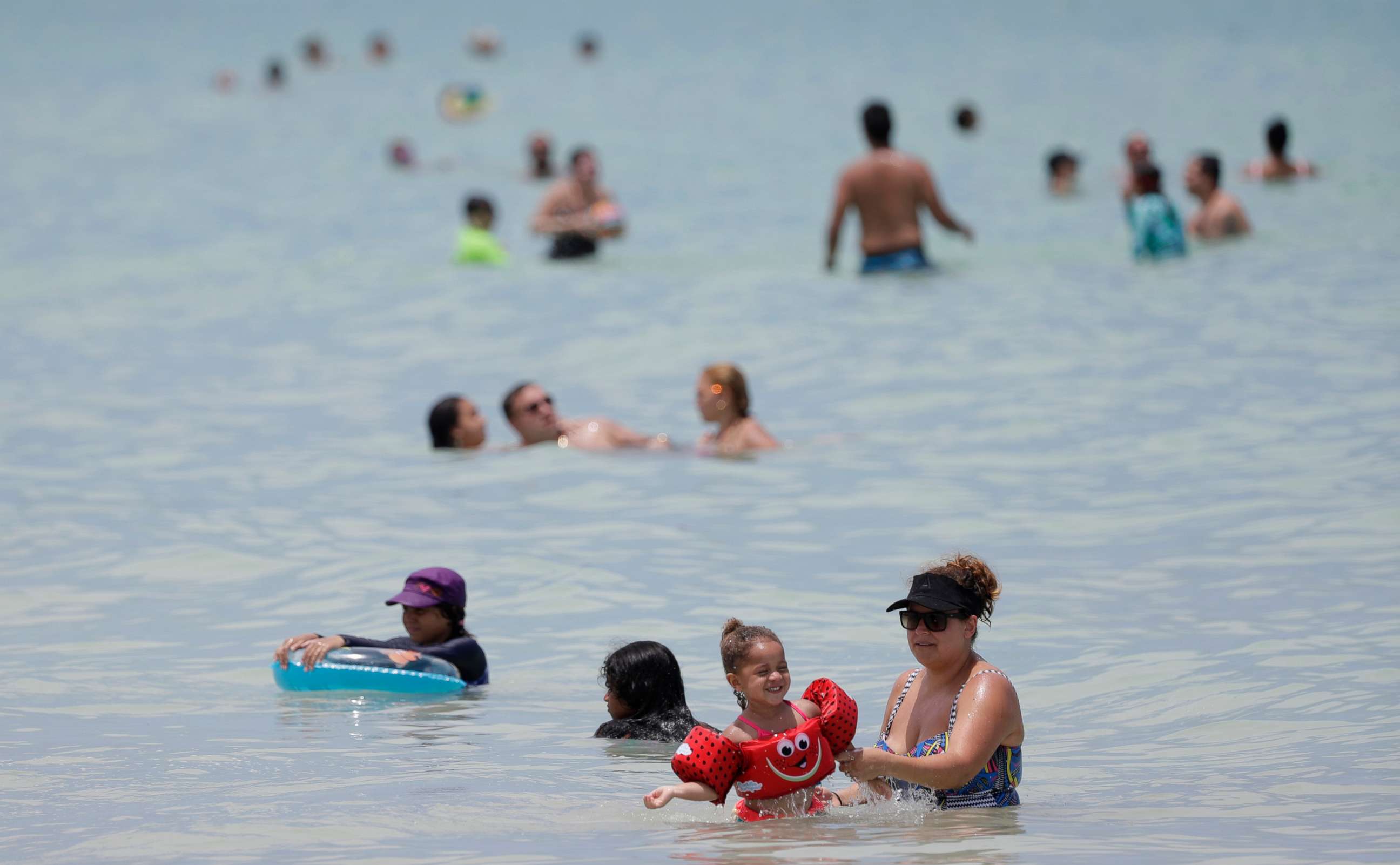 PHOTO: Beach goers swim in the tranquil waters off Miami Beach, Florida's famed South Beach, July 7, 2020.