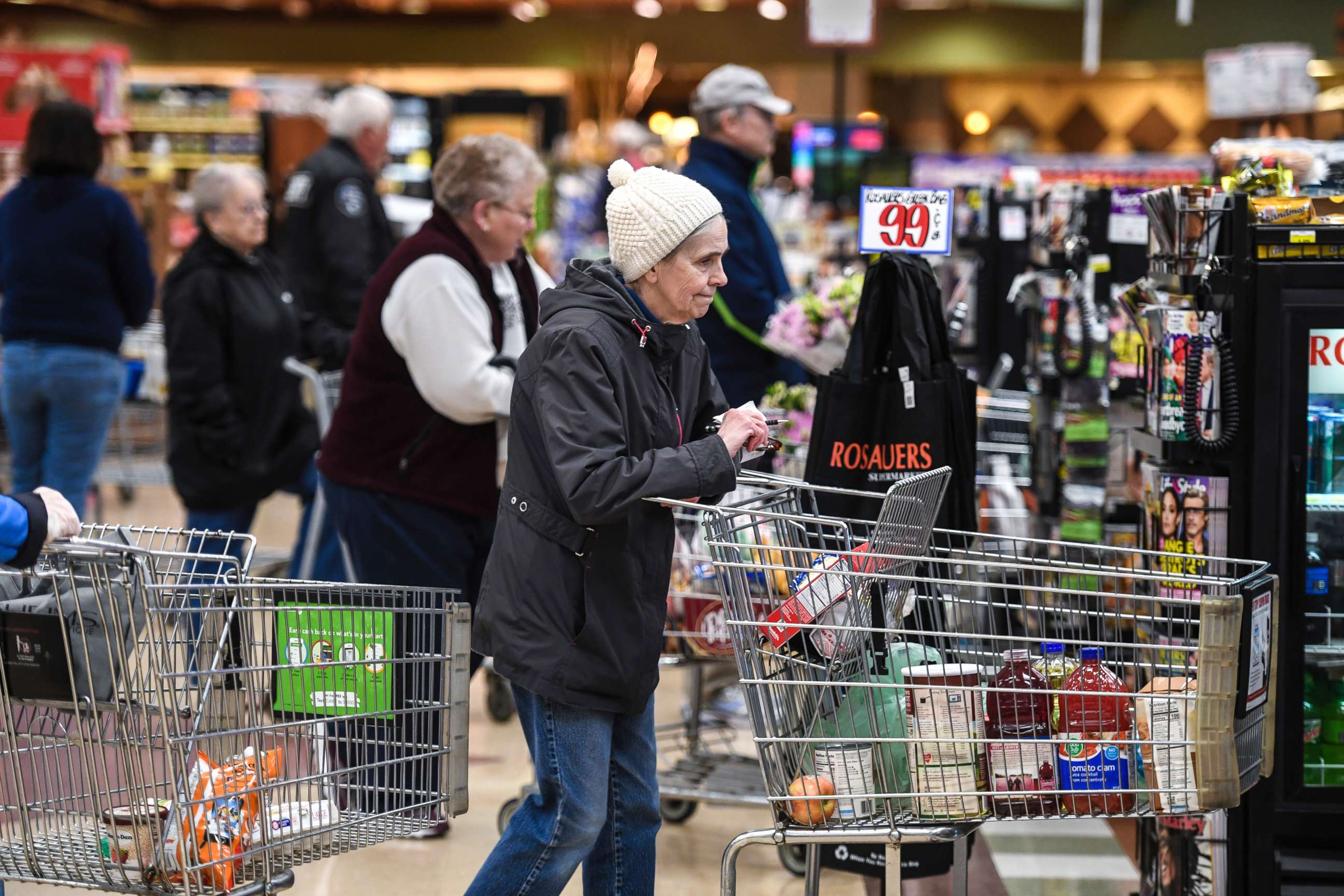 PHOTO: Shopper Patty Rowley waits in the checkout line during senior and at-risk shopping at a grocery store in Spokane, Wash., March 19, 2020.