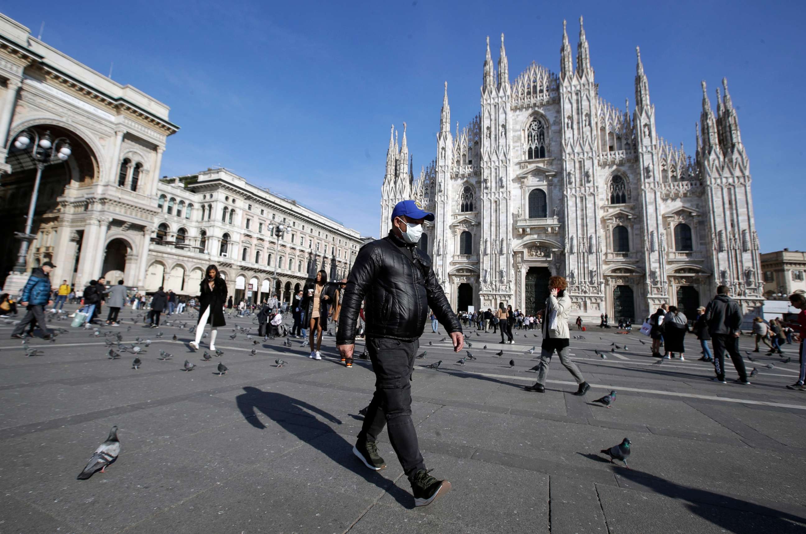 PHOTO: a man walks past the Duomo gothic cathedral in Milan, Italy.