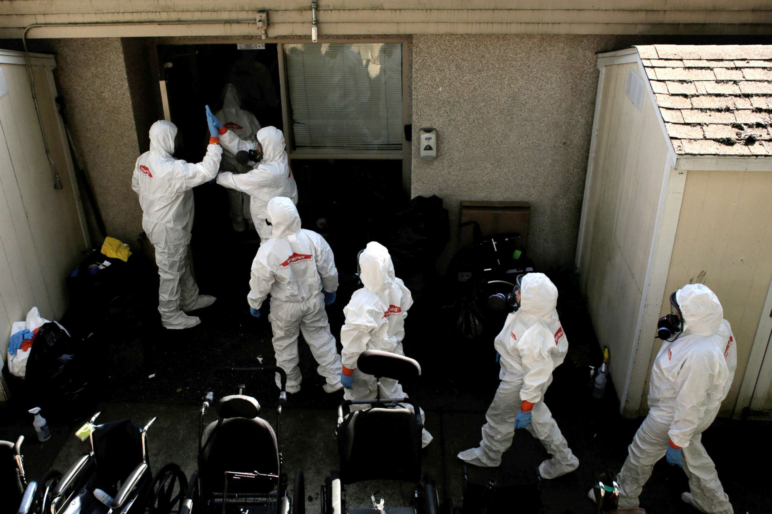 PHOTO: Members of a cleaning crew high-five before entering the Life Care Center of Kirkland, the Seattle-area nursing home at the epicenter of one of the biggest coronavirus outbreaks in the US, in Kirkland, Washington, March 12, 2020. 