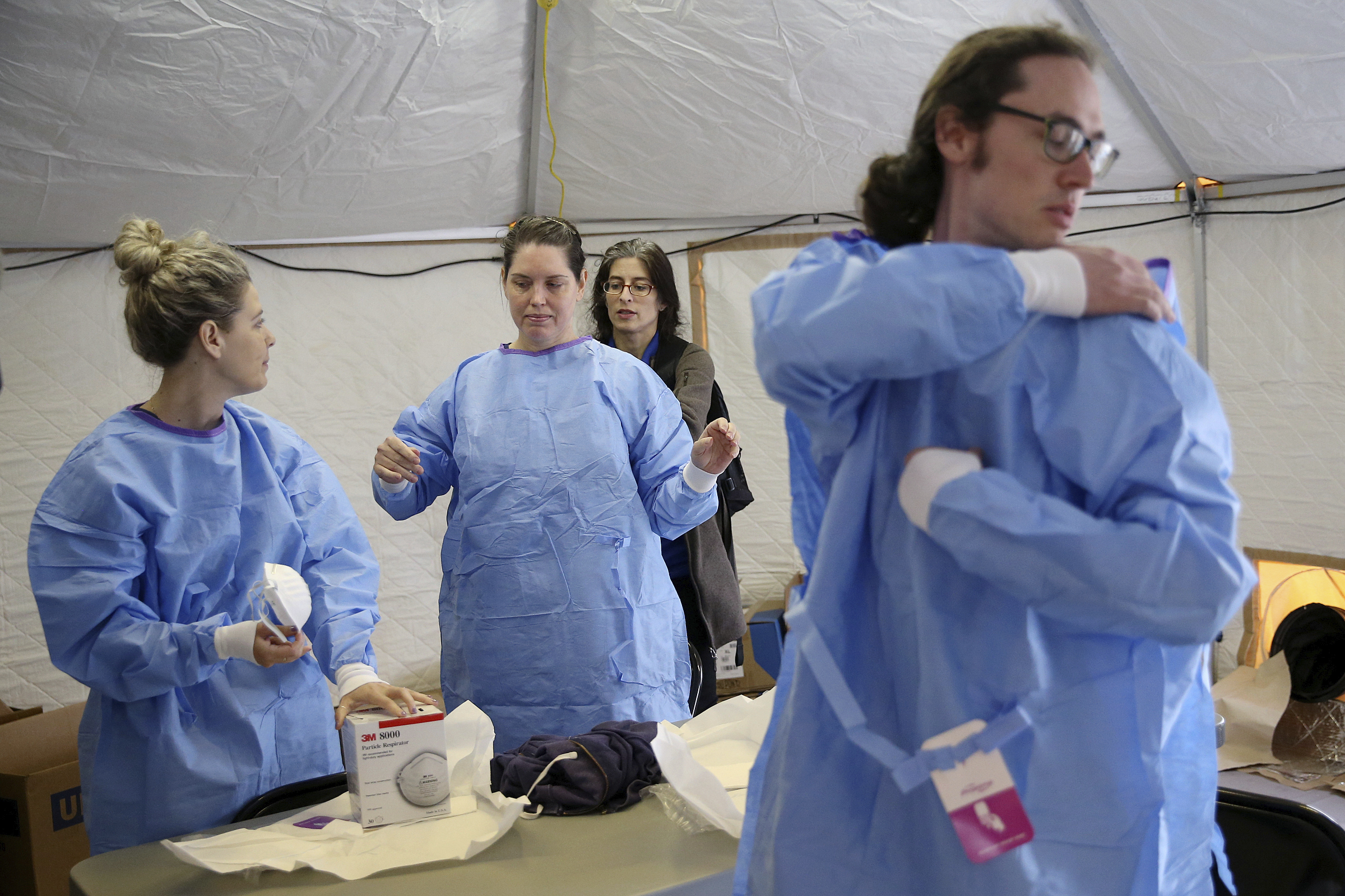 PHOTO: Philadelphia Medical Reserve Corps volunteers, all of whom are nurses, put on their protective outfits as a coronavirus testing site prepared to open in South Philadelphia on Friday, March 20, 2020.