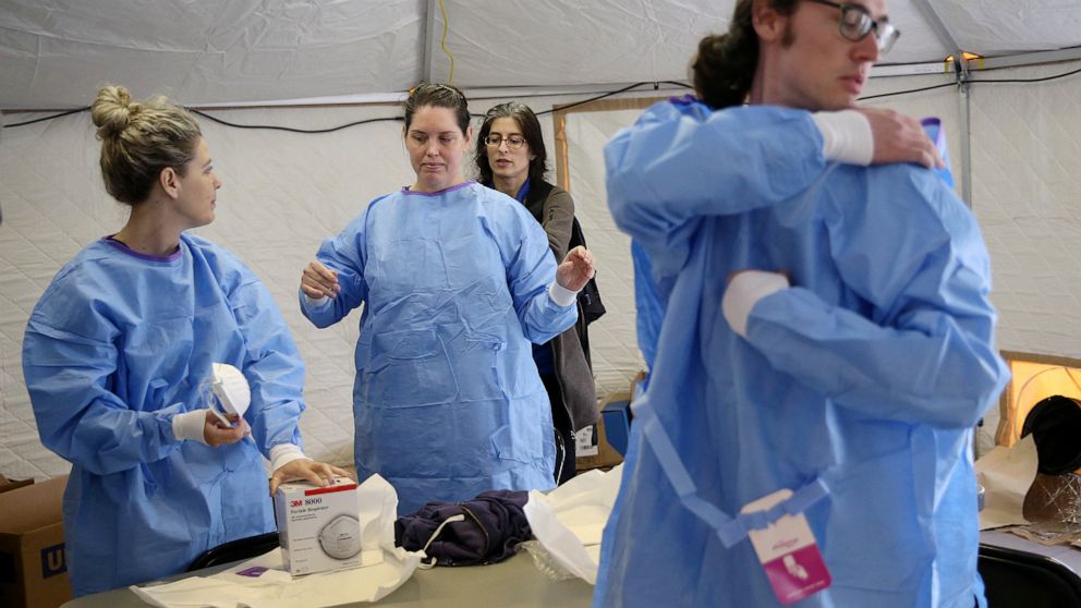 PHOTO: Philadelphia Medical Reserve Corps volunteers, all of whom are nurses, put on their protective outfits as a coronavirus testing site prepared to open in South Philadelphia on Friday, March 20, 2020.