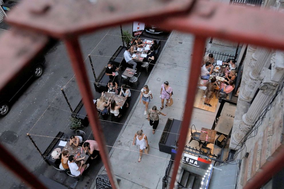 PHOTO: People eat outside of LENA Winebar as restaurants are permitted to offer al fresco dining as part of phase 2 reopening during the coronavirus disease (COVID-19) outbreak in the Lower East Side of New York City, June 27, 2020.