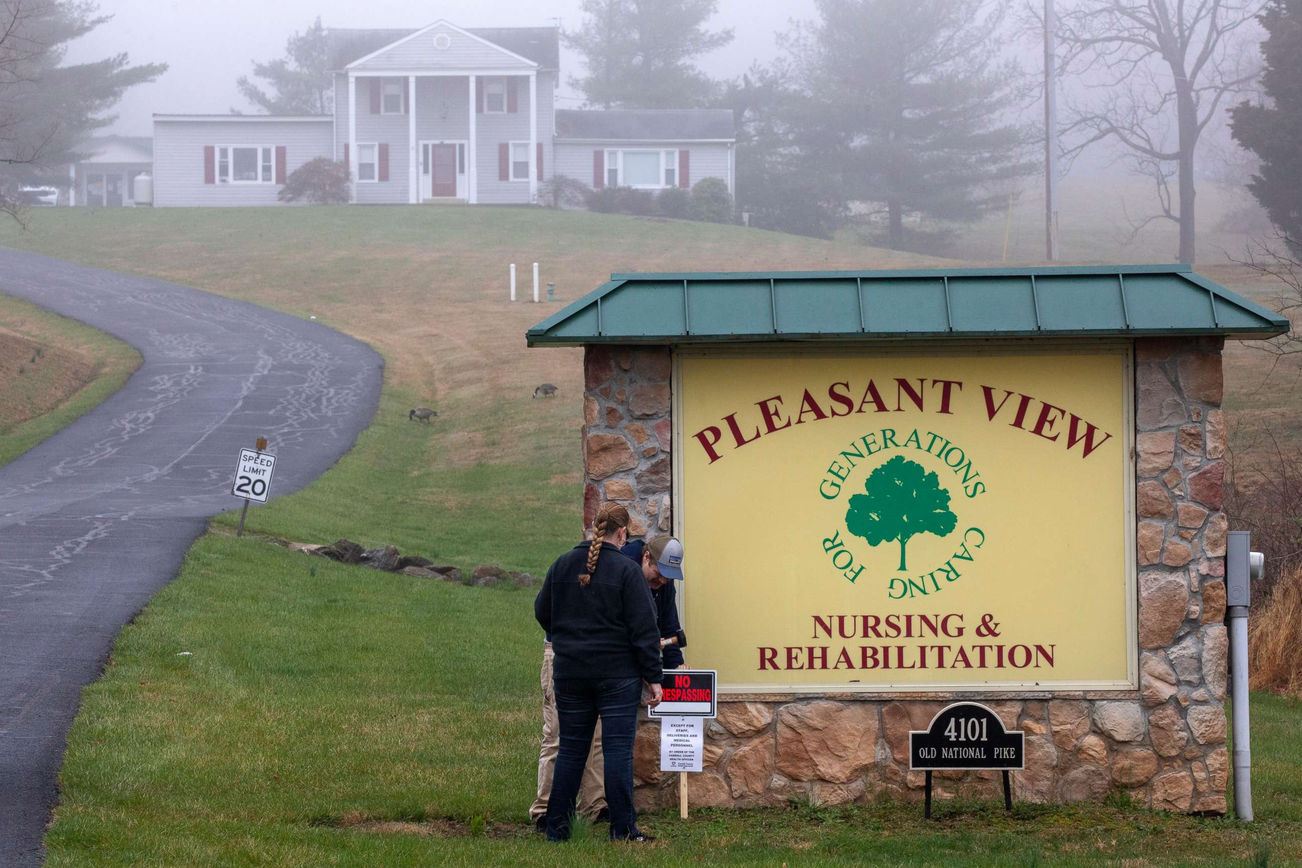 PHOTO: In the fog, Carroll County Health Department personnel place a "no trespassing" sign by the driveway of the Pleasant View Nursing Home, in Mount Airy, Md., Sunday, March 29, 2020.