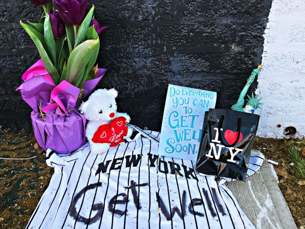 PHOTO: A "Get Well" message for New York, with a Yankees shirt and masked Statue of Liberty, lies on a street in the Brooklyn borough of New York City, March 27, 2020. 