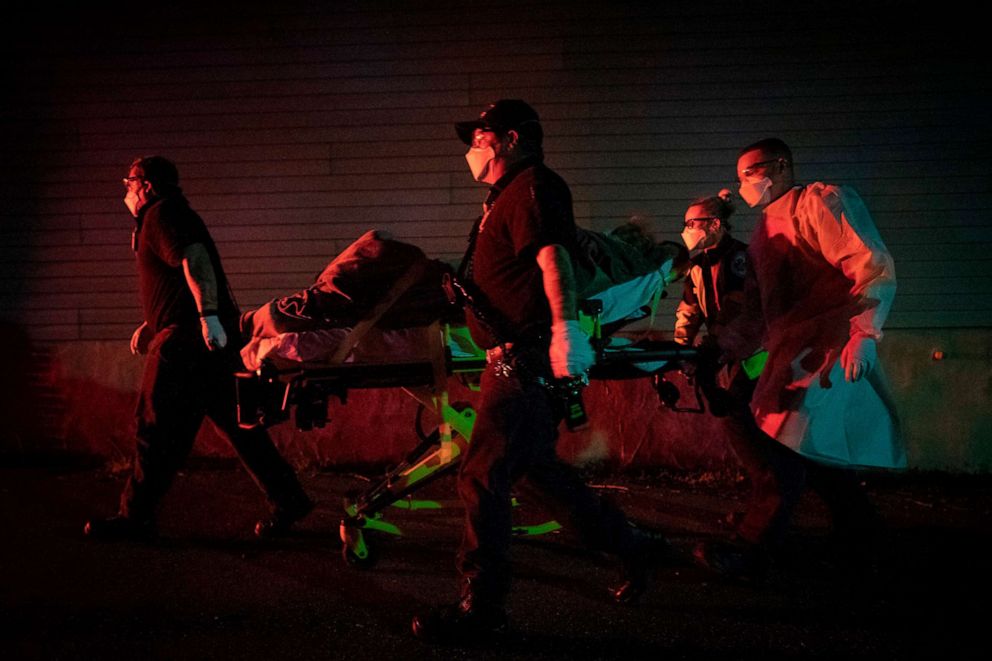 PHOTO: In this file photo taken on April 13, 2020, firefighters and paramedics with the Anne Arundel County Fire Department transport a patient on a stretcher in Glen Burnie, a suburb of Baltimore, Maryland.