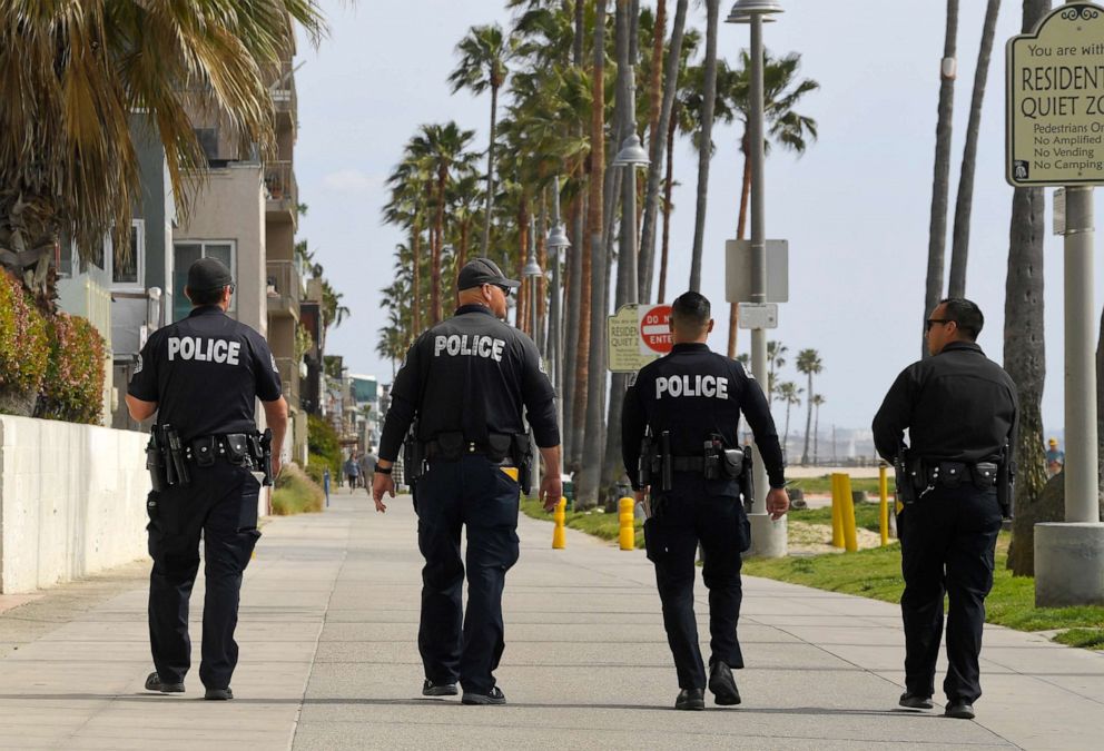 PHOTO: Los Angeles police officers patrol a sparsely populated Venice Beach boardwalk, March 28, 2020, in Los Angeles.
