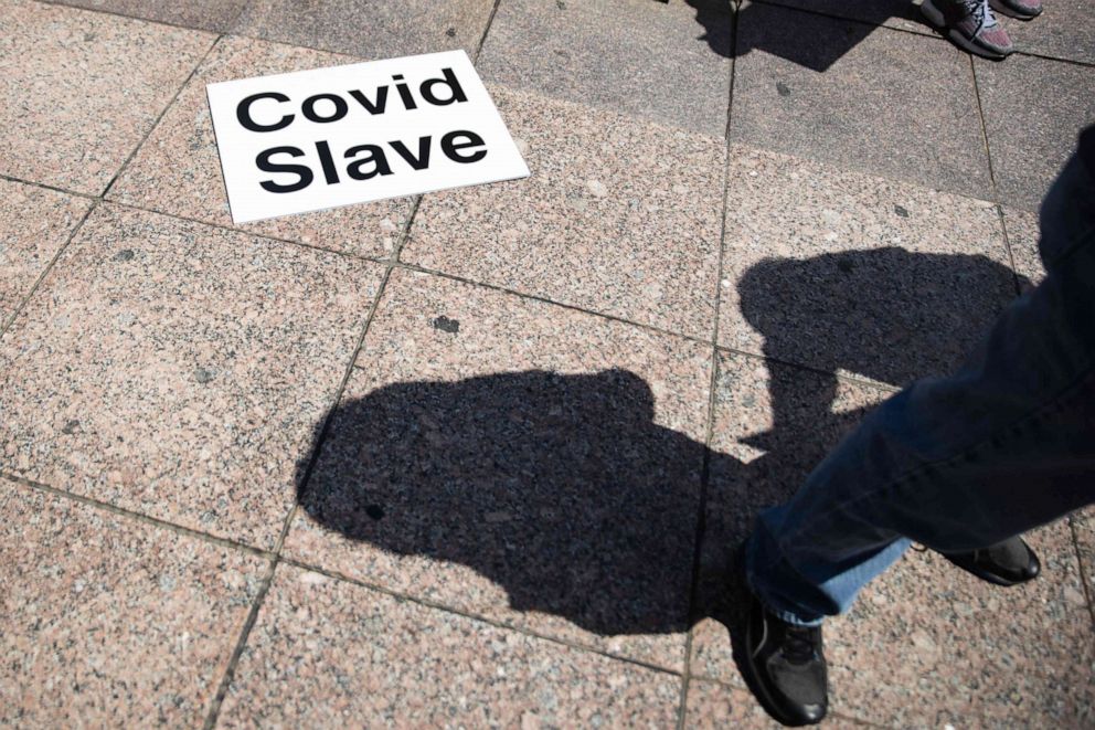 PHOTO: A sign lies on the ground that reads 'COVID slave' outside of the Ohio State House in Columbus, Ohio, on April 18, 2020, to protest the stay-at-home order that is in effect until May 1 due to the novel coronavirus pandemic.