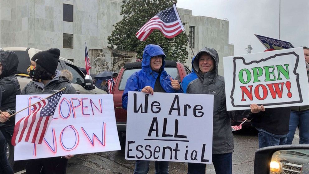 PHOTO: People hold signs outside the Oregon State Capitol in Salem on May 2, 2020, to protest Gov. Kate Brown's executive order that shut down much of the state's economy and imposed social distancing to stem the spread of the novel coronavirus.