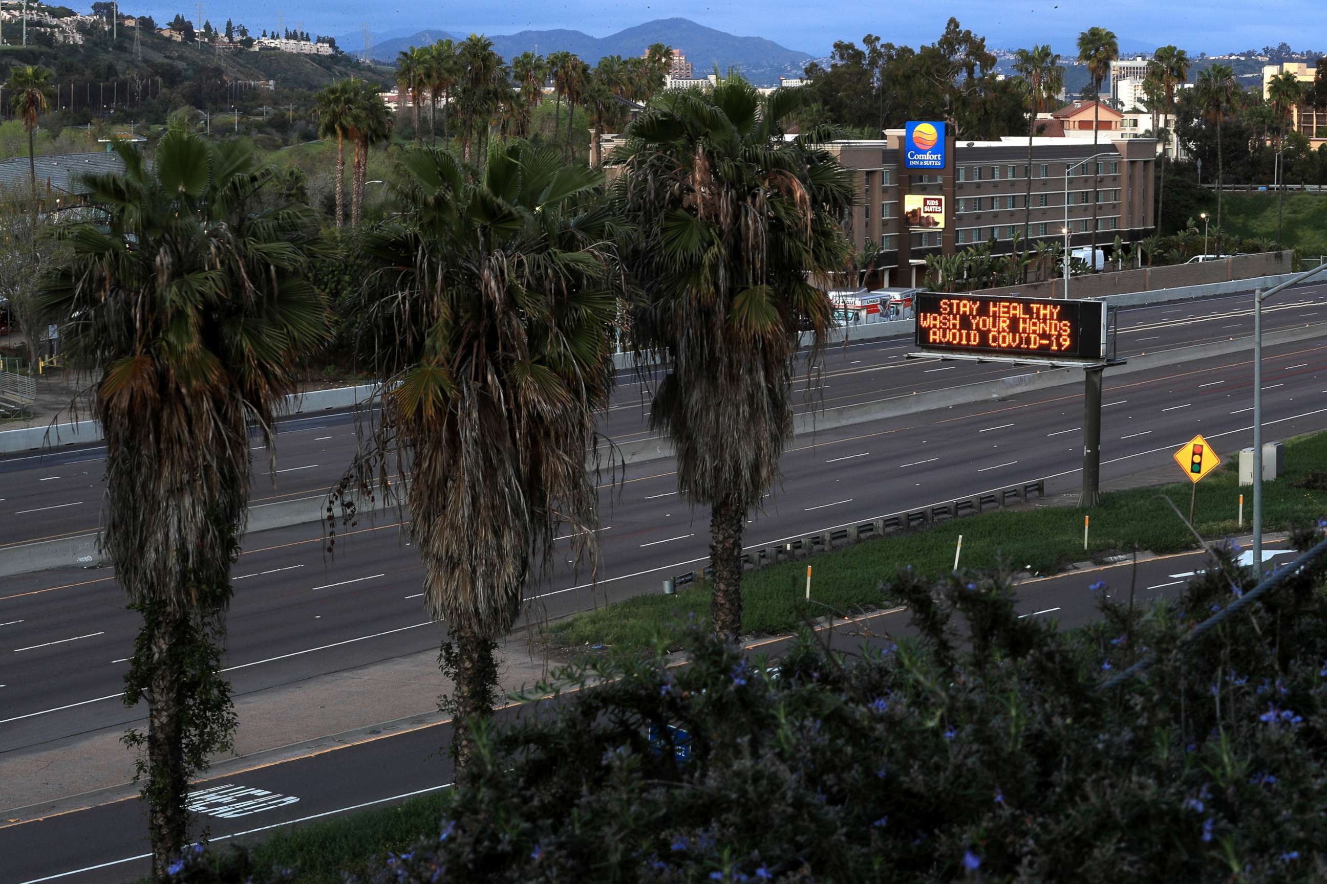 PHOTO: A stretch of Interstate 8 is empty as a sign encourages hand washing on March 15, 2020 in San Diego, Calif. 