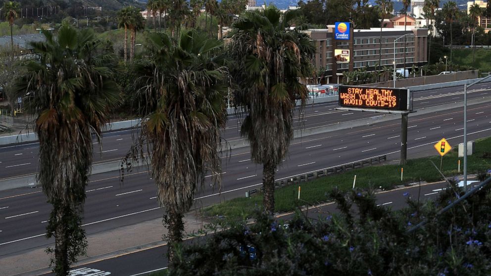 PHOTO: A stretch of Interstate 8 is empty as a sign encourages hand washing on March 15, 2020 in San Diego, Calif. 