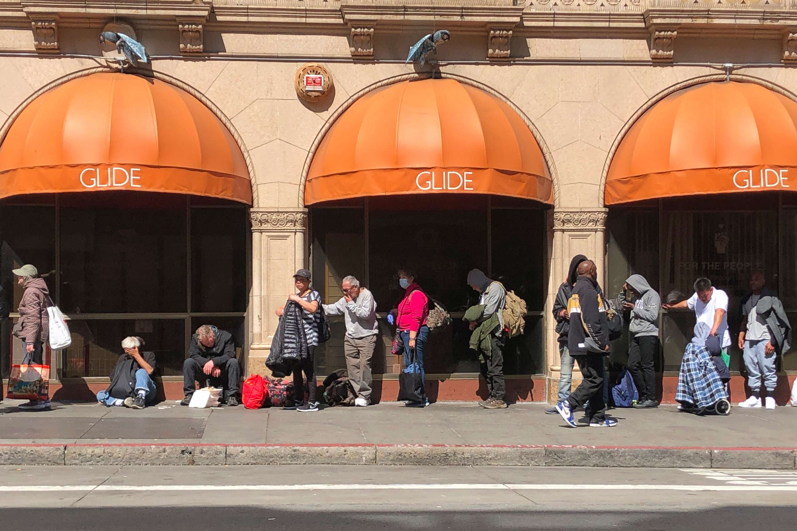 PHOTO: People line up outside GLIDE, a charity that offers free meals, a shelter and other services to the homeless, March 20, 2020, in San Francisco.