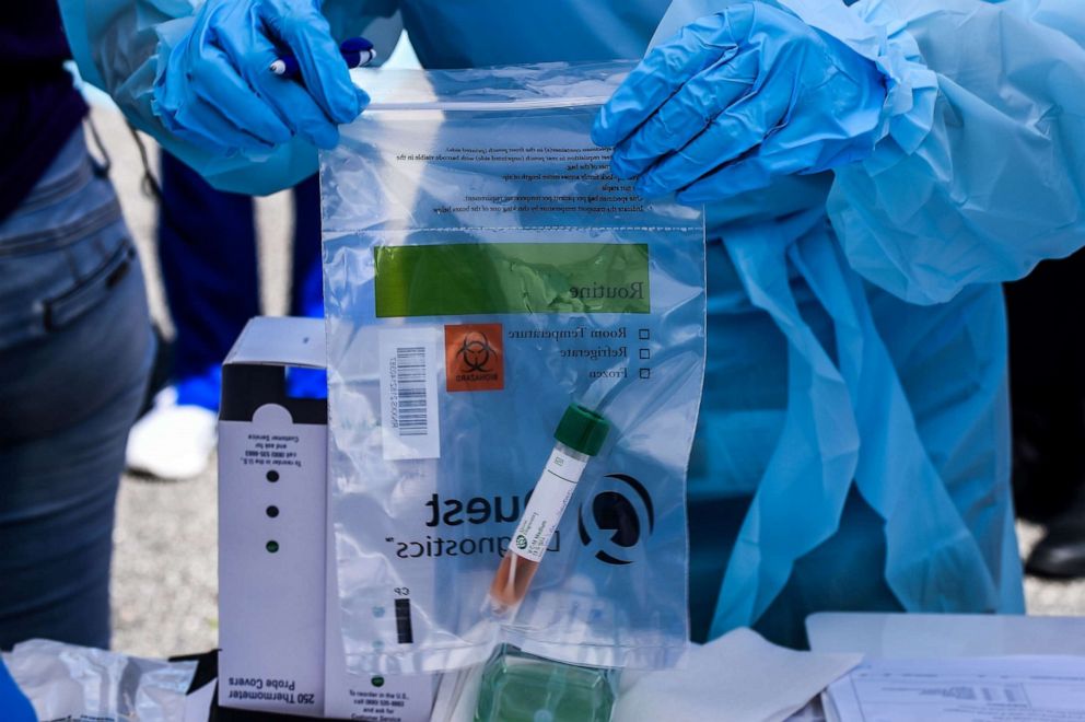 PHOTO: In this file photo taken on March 16, 2020, a health worker stores medical samples of patients at a drive-thru coronavirus testing lab set up by a local community center in West Palm Beach, Florida.