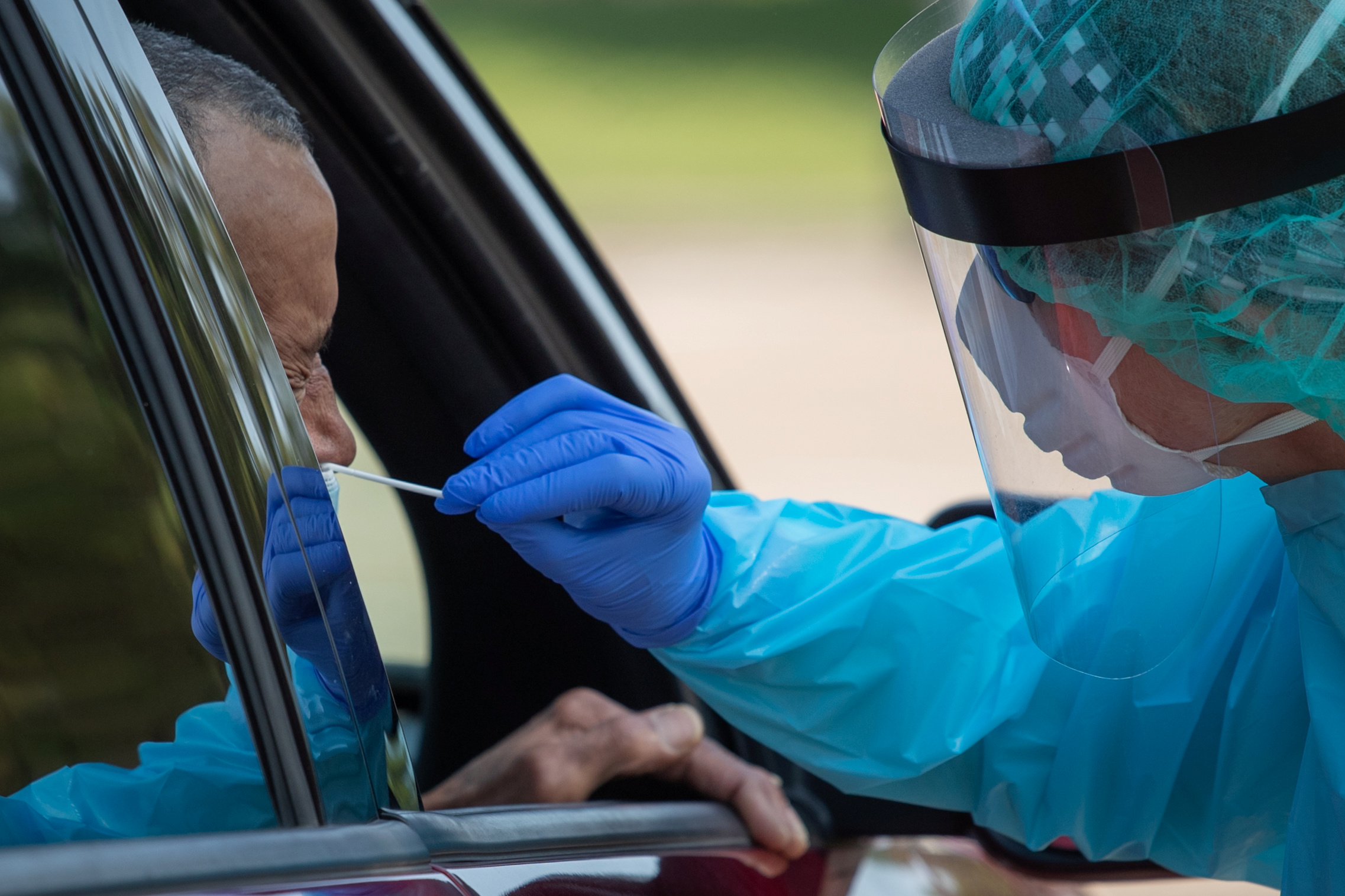 PHOTO: A health care worker uses a swab to test a man for COVID-19 at a drive-in testing location in Houston, Texas, on Aug. 18, 2020.