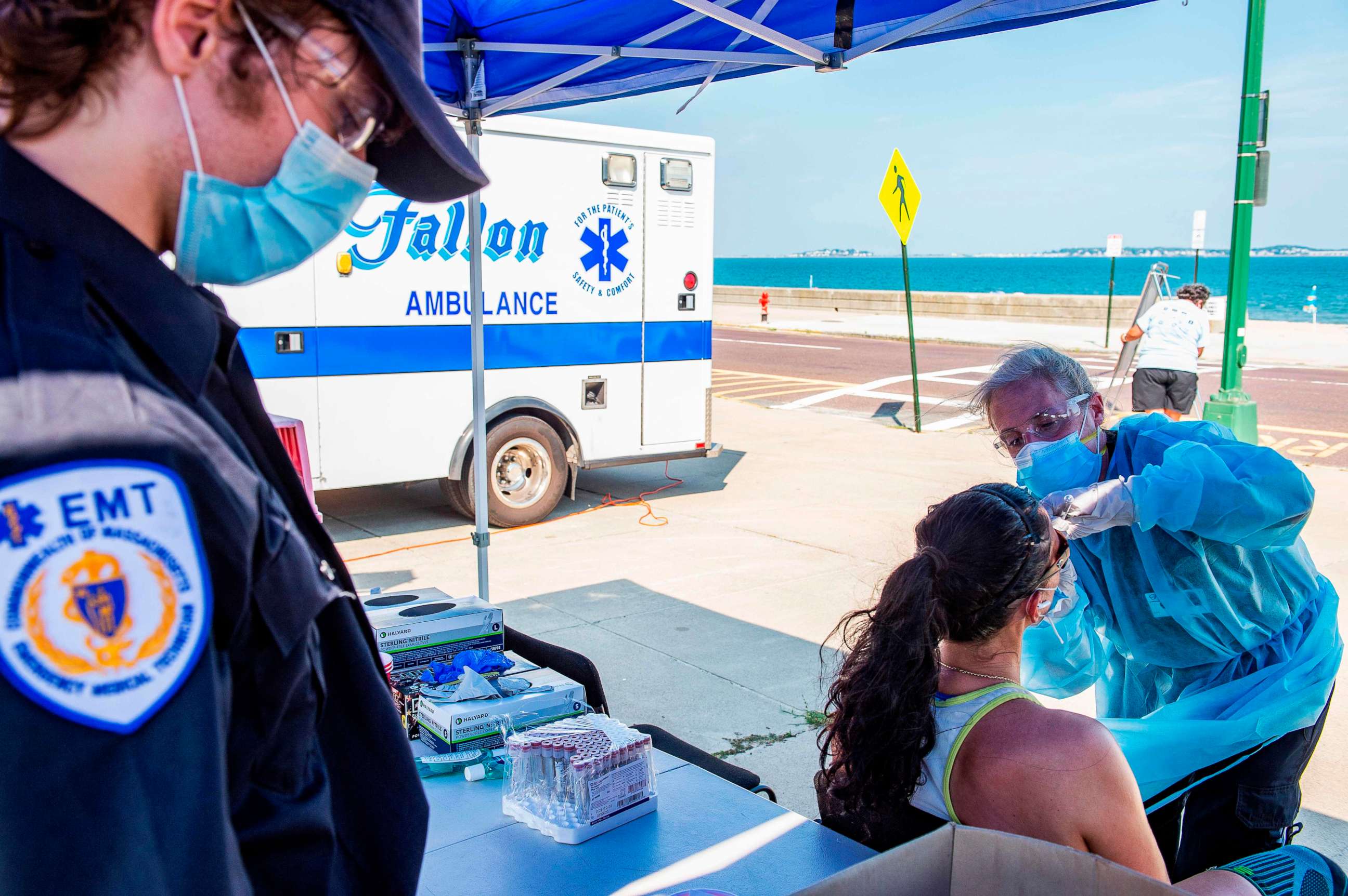 PHOTO: A health worker tests a woman for COVID-19 at a pop-up testing location on the boardwalk at Revere Beach in Revere, Massachusetts, on Aug. 11, 2020.