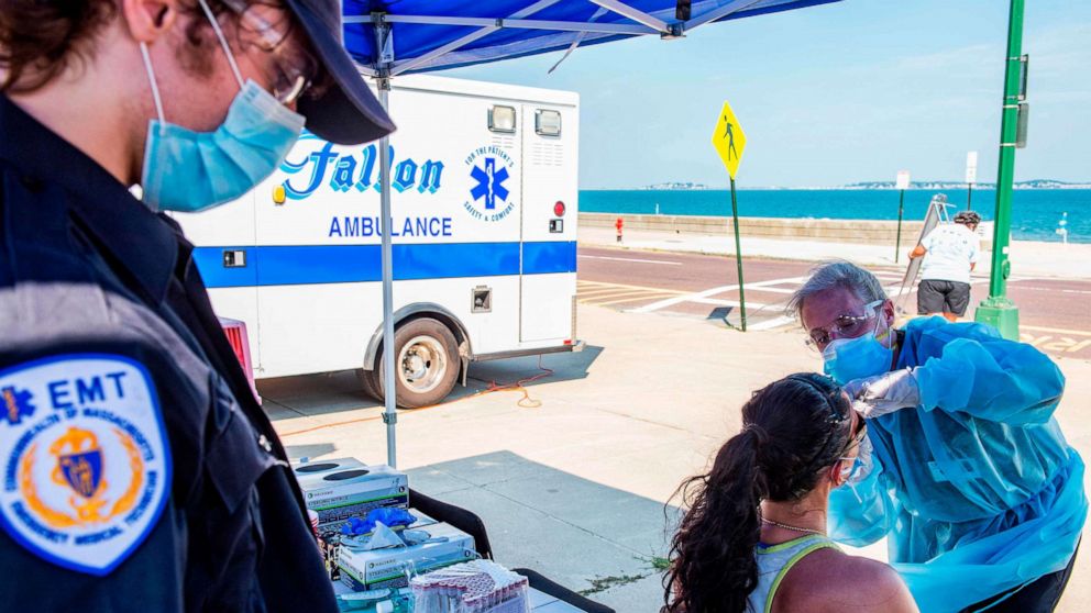 PHOTO: A health worker tests a woman for COVID-19 at a pop-up testing location on the boardwalk at Revere Beach in Revere, Massachusetts, on Aug. 11, 2020.