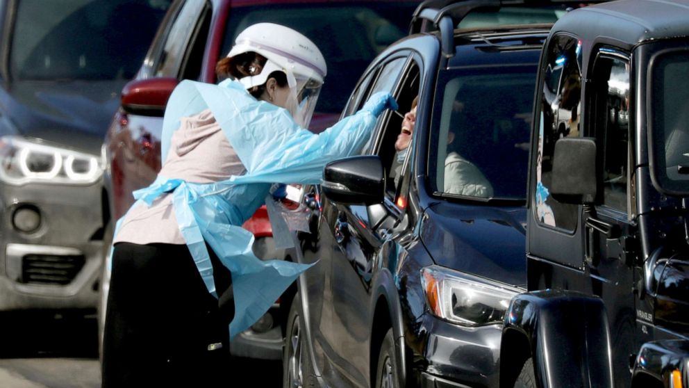 PHOTO: Health care worker tests people at a drive-thru testing station run by the state health department, for people who suspect they have novel coronavirus, in Denver, Colorado, March 11, 2020.