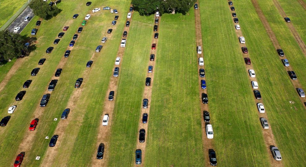 PHOTO: Cars form a queue in a field as hundreds of people arrive to be tested for COVID-19 at a drive through testing site in Kissimmee, Fla., July 14, 2020.