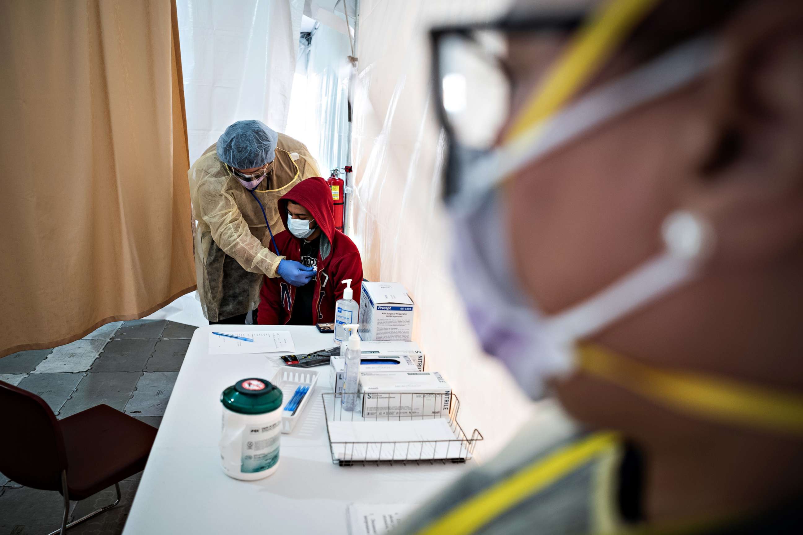 PHOTO: A doctor examines Juan Vasquez for a COVID-19 test inside a testing tent at St. Barnabas hospital, on March 20, 2020, in New York City.