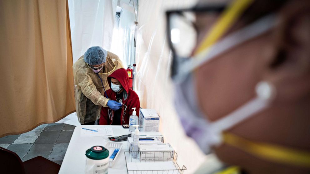 PHOTO: A doctor examines Juan Vasquez for a COVID-19 test inside a testing tent at St. Barnabas hospital, on March 20, 2020, in New York City.