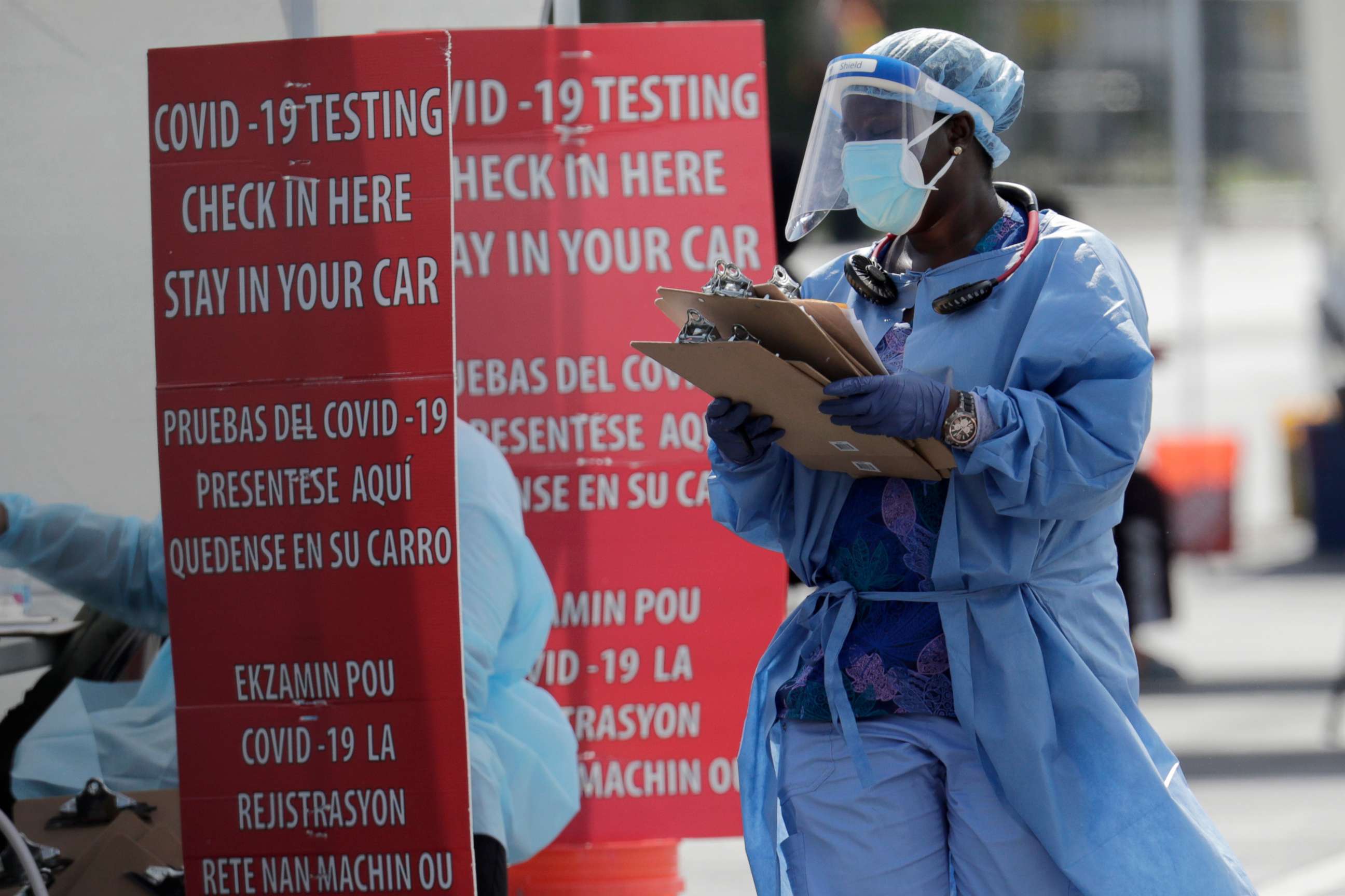 PHOTO: A health care worker carries a stack of clipboards at a COVID-19 testing site sponsored by Community Heath of South Florida at the Martin Luther King, Jr. Clinica Campesina Health Center in Homestead, Florida, on July 6, 2020.