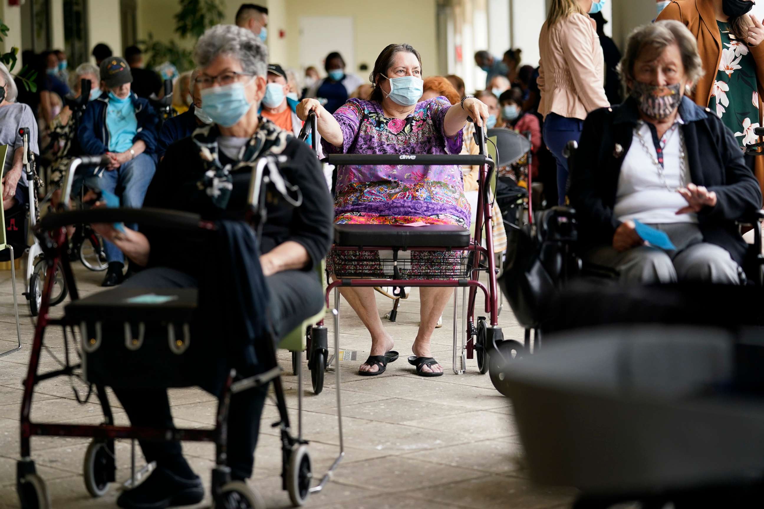 PHOTO: Resident Sabeth Ramirez, 80, center, waits in line with others for the Pfizer-BioNTech COVID-19 vaccine at the The Palace assisted living facility in Coral Gables, Fla., Jan. 12, 2021.