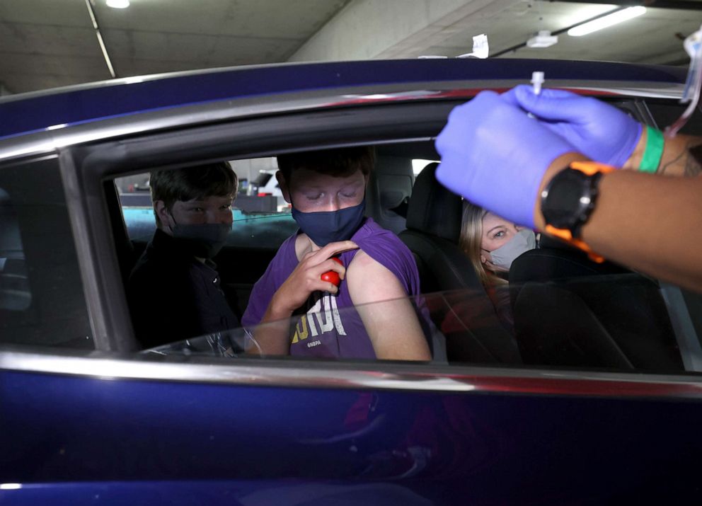 PHOTO: Ciaran Ford-Hemann, 12, pulls up his sleeve to receive a Pfizer COVID-19 vaccination at a drive-thru vaccine clinic on May 13, 2021, in San Jose, Calif.