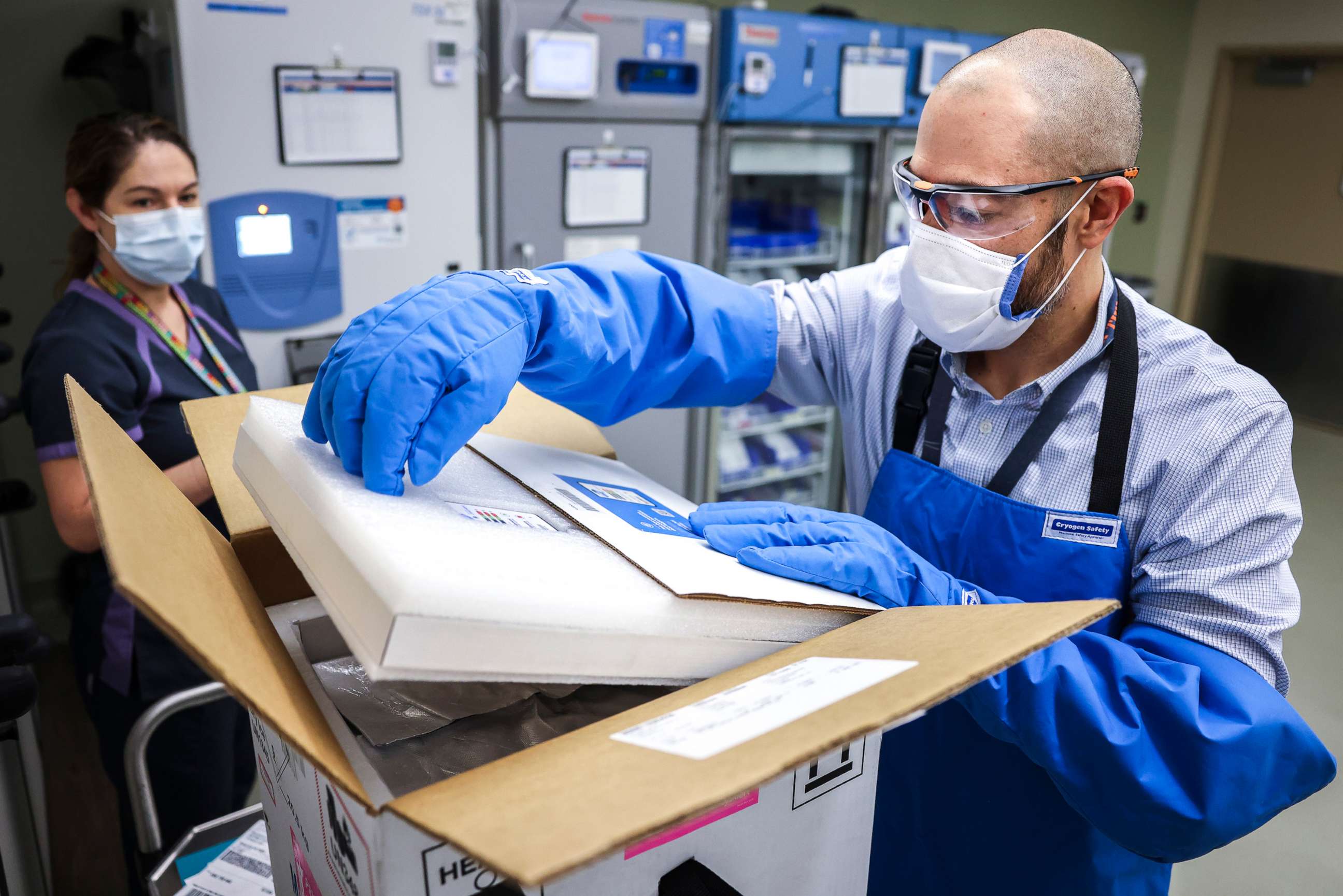 PHOTO: Rocky Mountain Regional VA Medical Center associate chief of pharmacy operations Terrence Wong opens a box containing a shipment of the Pfizer-BioNTech COVID-19 vaccine on Dec. 15, 2020, in Aurora, Colo.