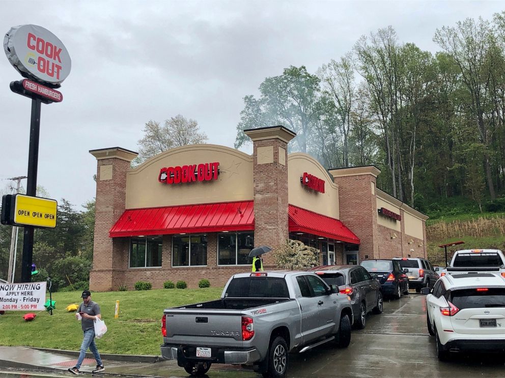 PHOTO: A customer leaves with a carry-out order at the newly opened Cook Out restaurant Thursday, April 23, 2020, in Cross Lanes, W.Va.
