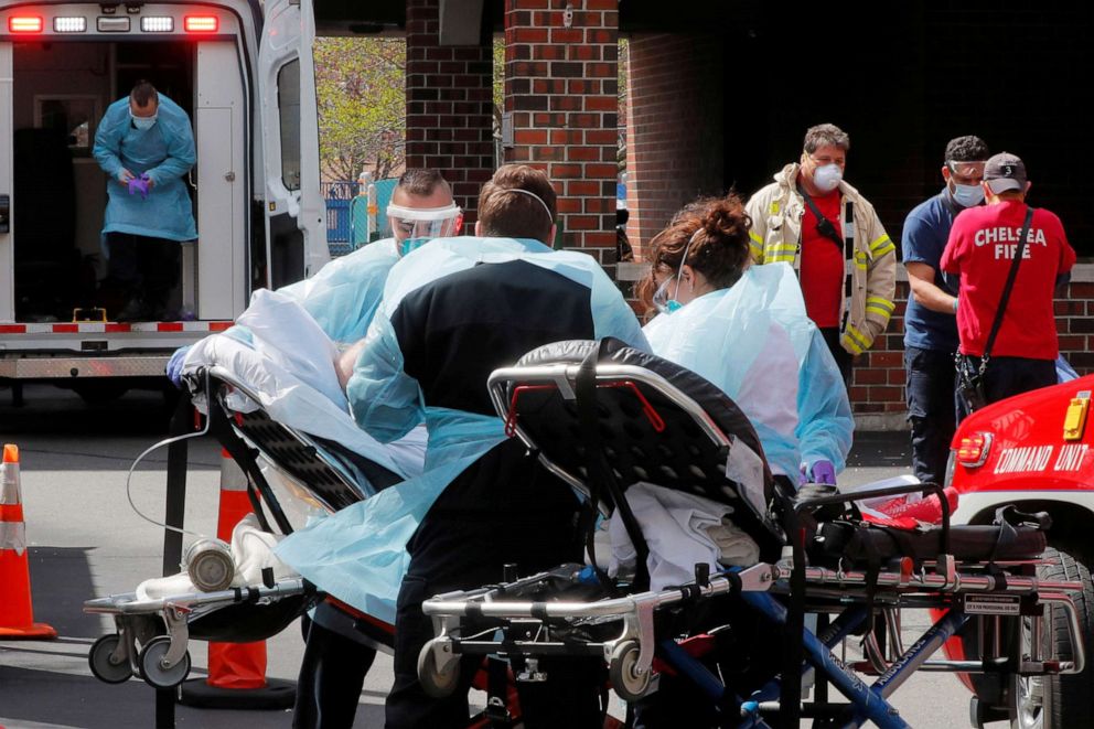 PHOTO: Cataldo Ambulance medics bring a patient who has tested positive for the coronavirus disease (COVID-19) to the ambulance at an assisted living facility in Chelsea, Mass., April 10, 2020.