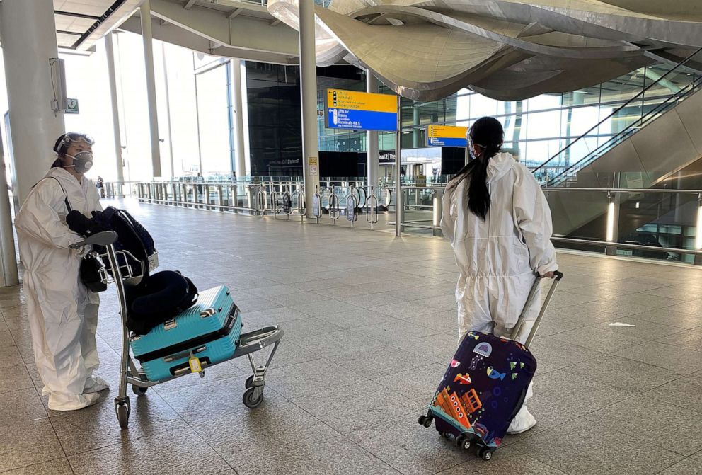 PHOTO: Passengers wearing protective clothing are seen at Heathrow Airport, amid the coronavirus disease (COVID-19) outbreak, in London, May 22, 2020.