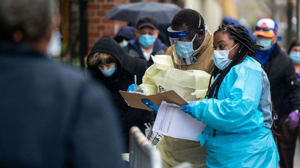 PHOTO: Medical workers assist people standing in line at NYC Health + Hospitals/Gotham Health, waiting to be tested for the coronavirus on April 24, 2020, in New York City.
