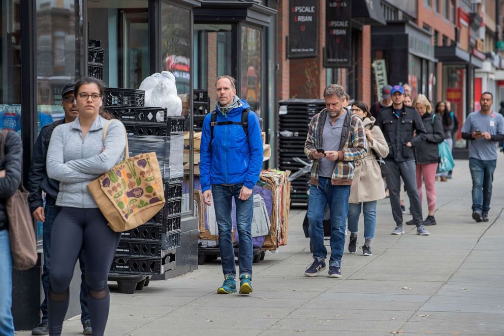 PHOTO: Customers keep their social distance from each other while waiting in line to enter and shop at a Trader Joe's grocery store in Washington, D.C., on March 31, 2020.