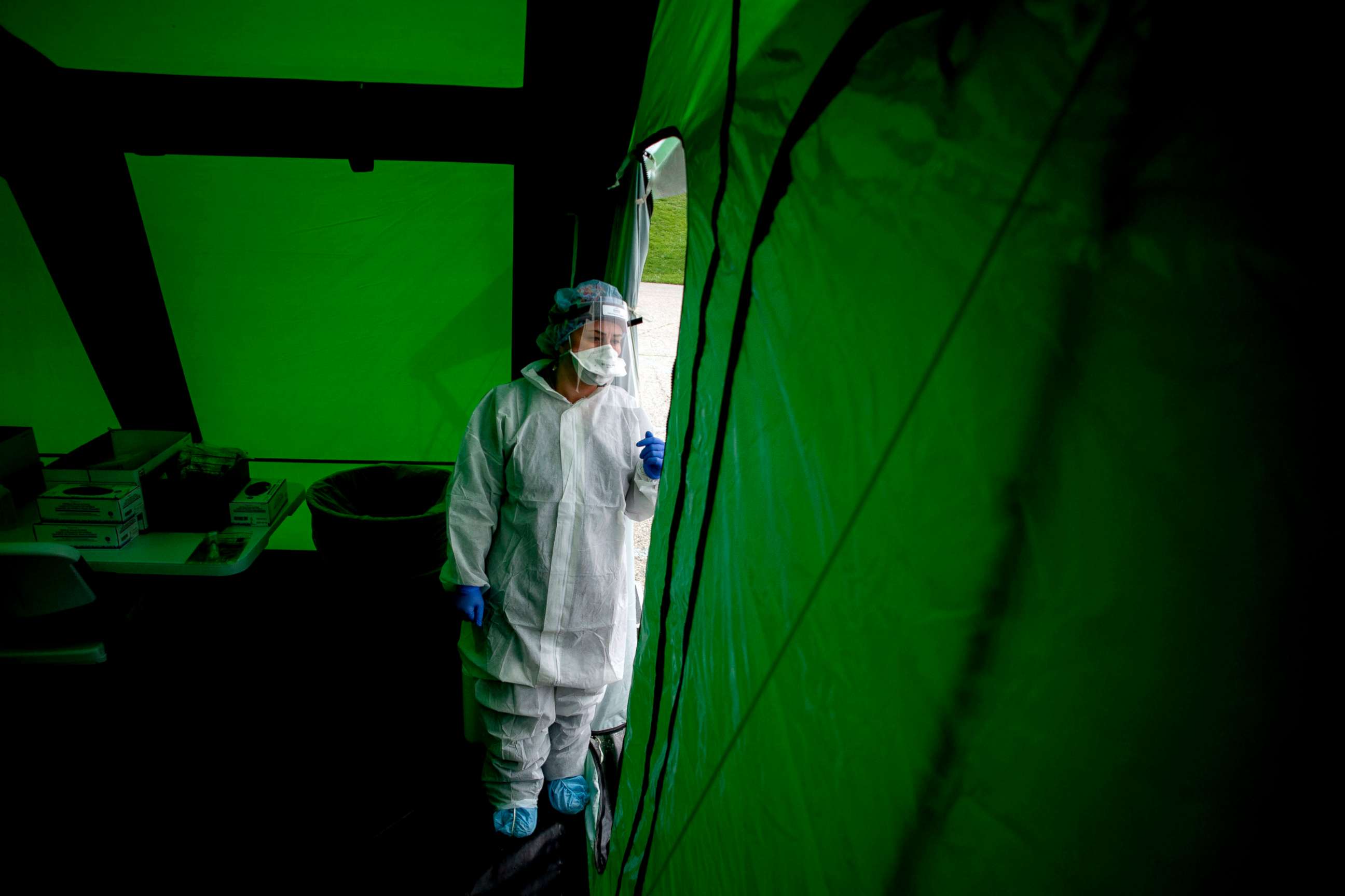 PHOTO: Amanda Zacek, a certified medical assistant from Swartz Creek, peeks out from the tent, April 15, 2020, at Atwood Stadium in Flint, Mich.