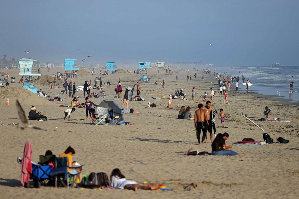 PHOTO: People gather at the beach on April 30, 2020 in Huntington Beach, Calif.