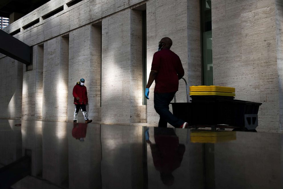 PHOTO: Two men, both wearing personal protection equipment, walk down 65th Street on May 5, 2020 in New York City.