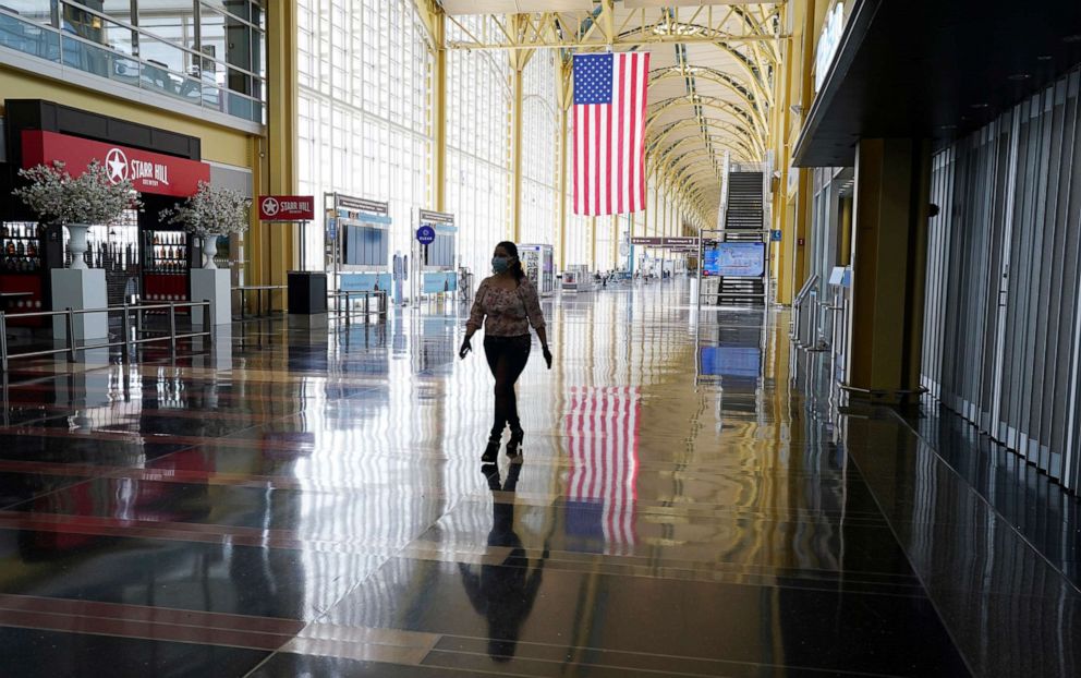 PHOTO:A woman walks through a mostly empty Reagan National airport in Washington, D.C., April 29, 2020.