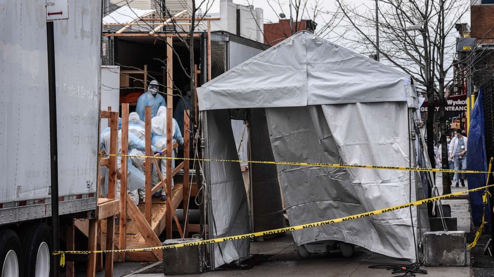 PHOTO: Medical workers are seen moving a body from the sidewalk into a refrigerator truck outside of Wyckoff Heights Medical Center in the borough of Brooklyn on April 3, 2020 in New York City.