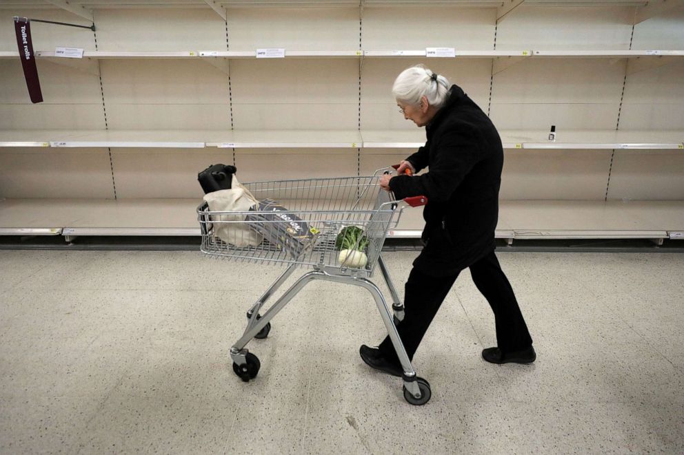 PHOTO:An elderly lady passes empty shelves in Sainsbury's supermarket as the coronavirus disease (COVID-19) outbreak continues, in Fulham, London, March 18, 2020.